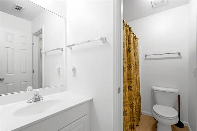 a bathroom with a sink a toilet and shower curtain