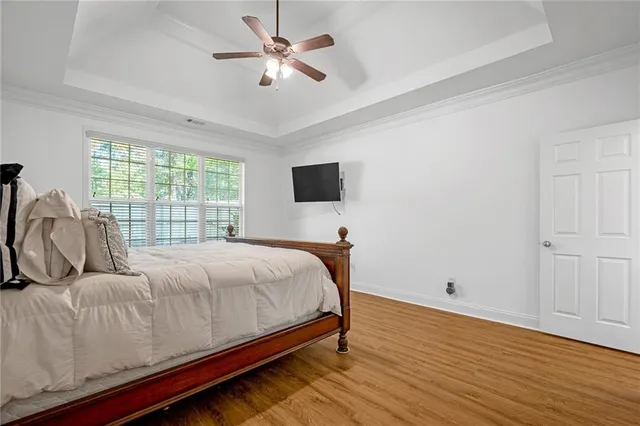a bedroom with a bed window and a flat tv screen