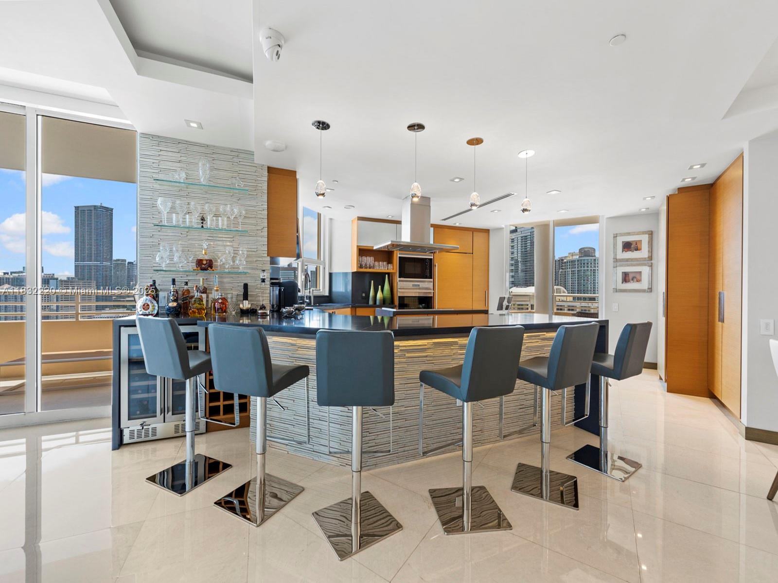 808 Brickell Key Drive, Unit 3208 Miami, FL 33131 - Photo 16 of 45 a kitchen with stainless steel appliances kitchen island granite countertop a table and chairs