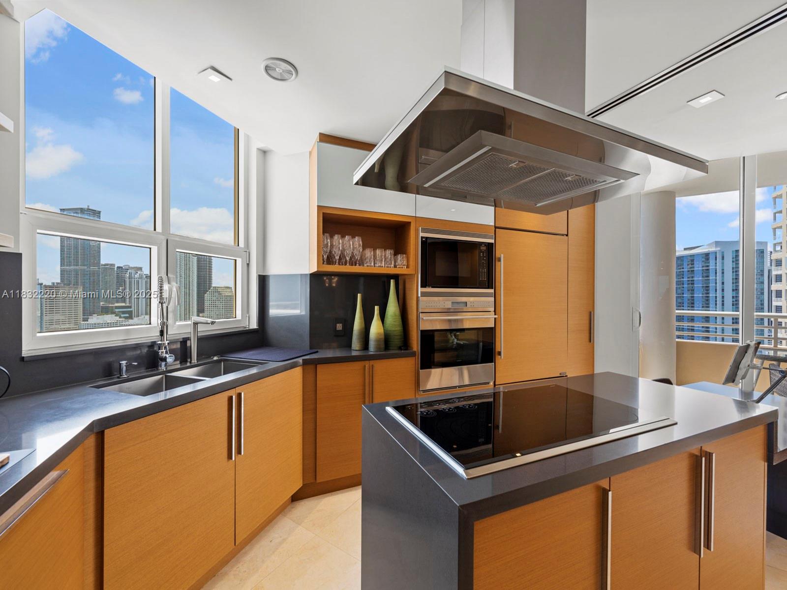 808 Brickell Key Drive, Unit 3208 Miami, FL 33131 - Photo 19 of 45 a kitchen with stainless steel appliances granite countertop a sink and a refrigerator