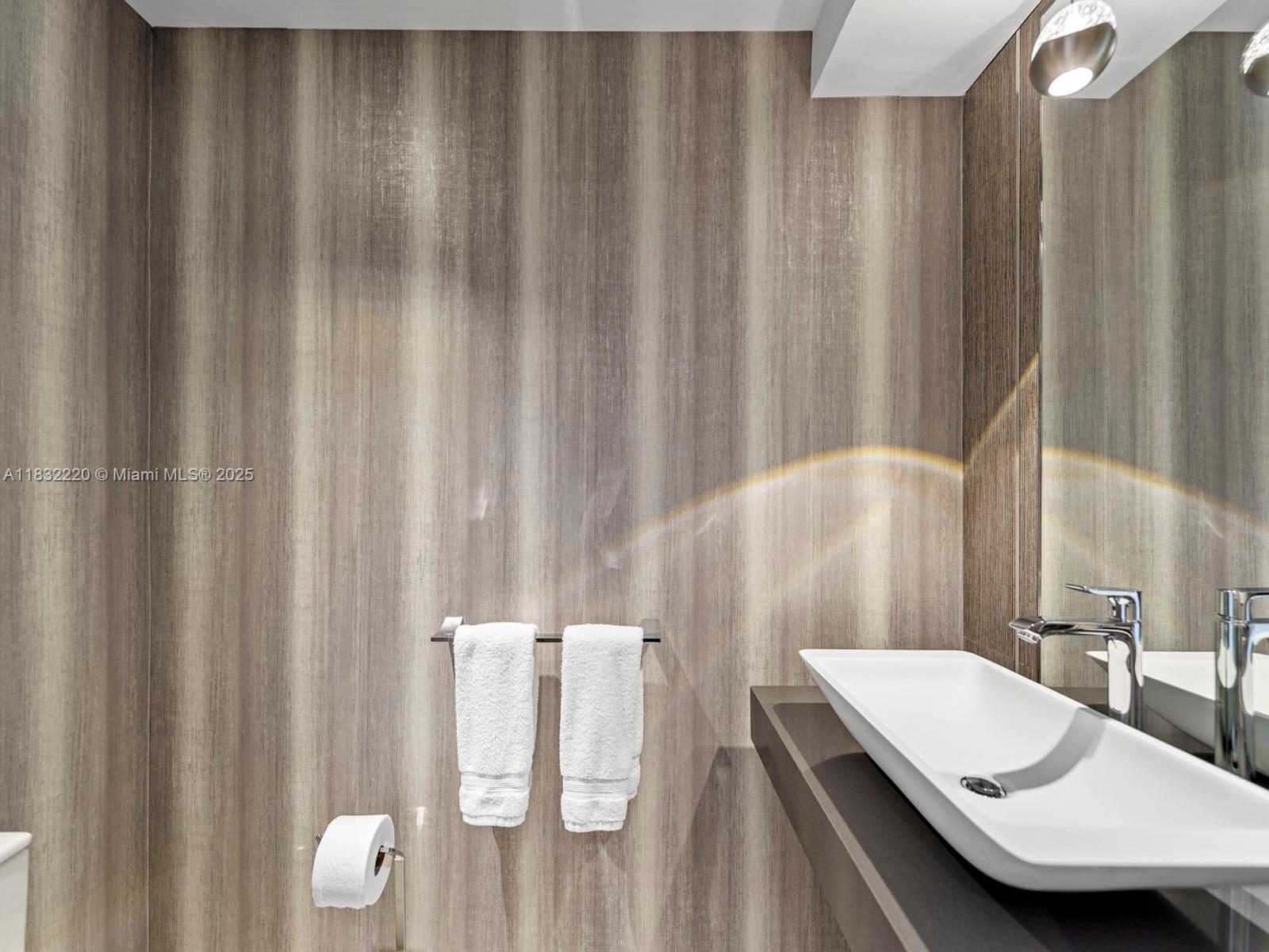 808 Brickell Key Drive, Unit 3208 Miami, FL 33131 - Photo 28 of 45 a bathroom with a sink and a mirror