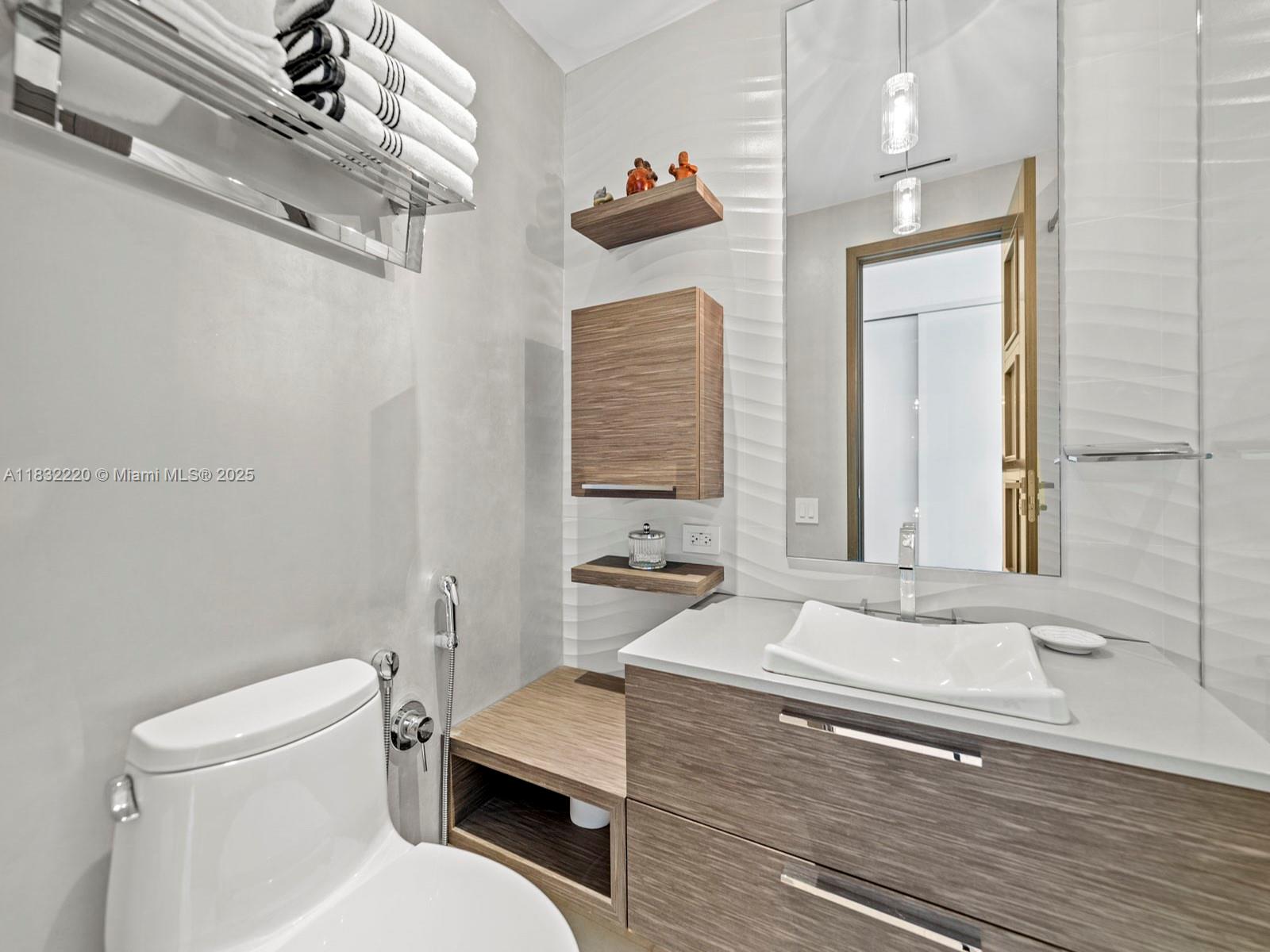 808 Brickell Key Drive, Unit 3208 Miami, FL 33131 - Photo 31 of 45 a bathroom with a sink a toilet and a mirror