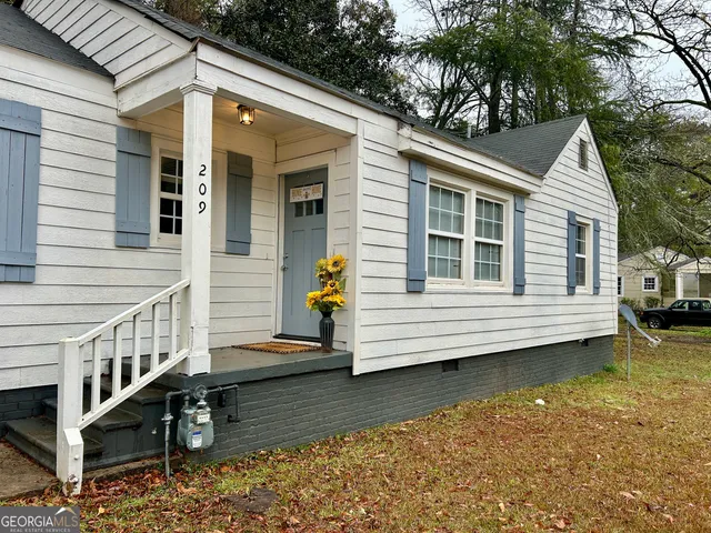 a view of a house with a yard and sitting area