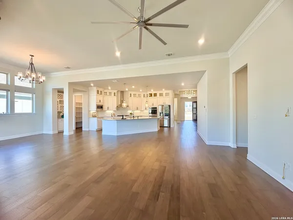 an empty room with wooden floor fireplace and windows