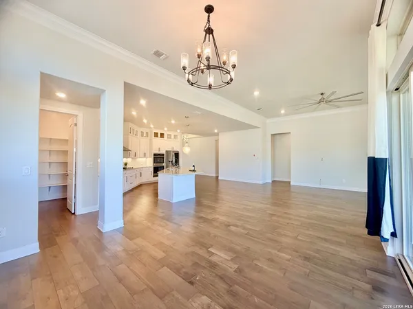 a view of a big room with wooden floor and windows