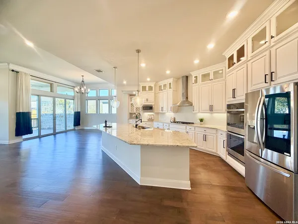 a large kitchen with granite countertop a large counter top stainless steel appliances and cabinets