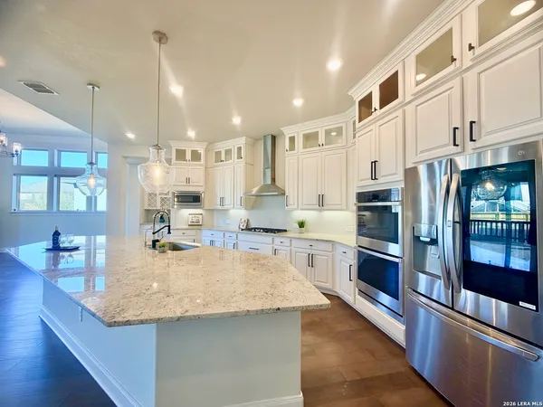 a large kitchen with lots of counter space wooden floor and appliances