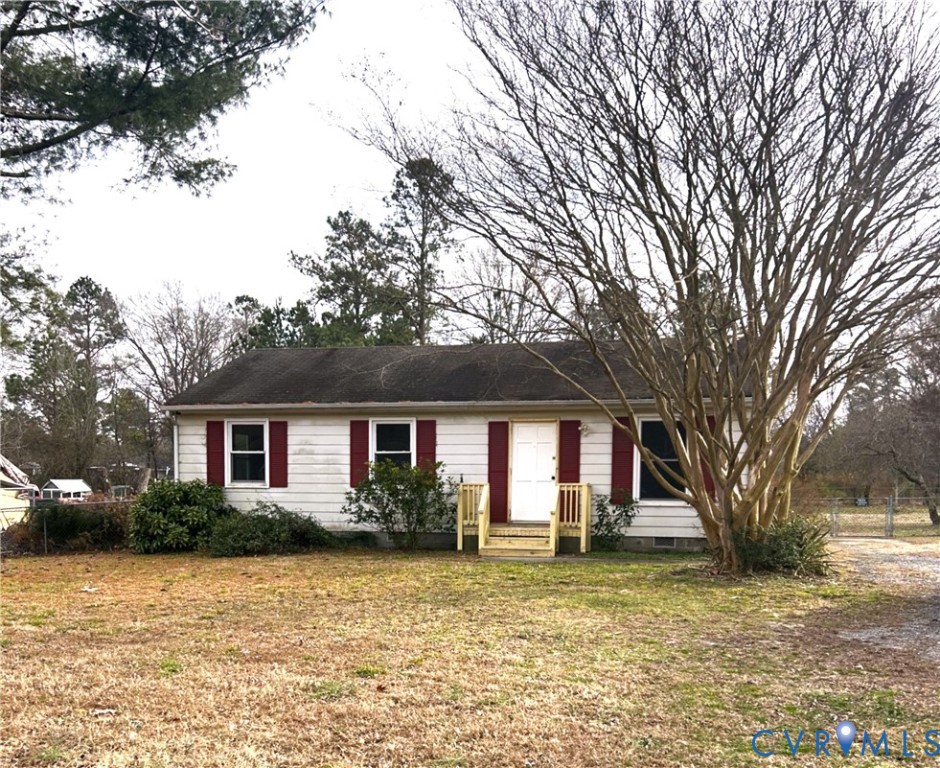a front view of house with yard and trees around