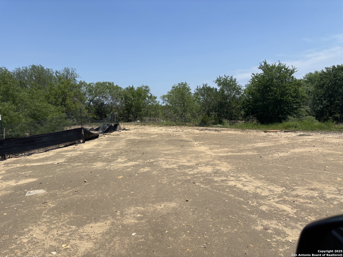 5353 Labus Road Elmendorf, TX 78112 - Photo 7 of 11 a backyard of a house with lots of green space and trees in the background