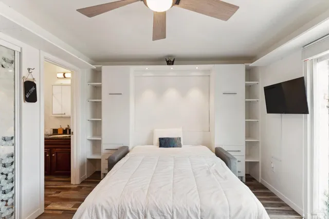 a bedroom with a large bed and a flat tv screen