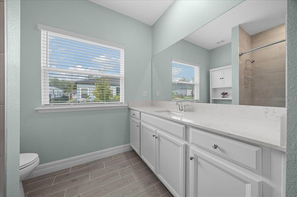 1130 Southeast 42nd Road Ocala, FL 34480 - Photo 49 of 83 a bathroom with a sink a toilet a large mirror and a window