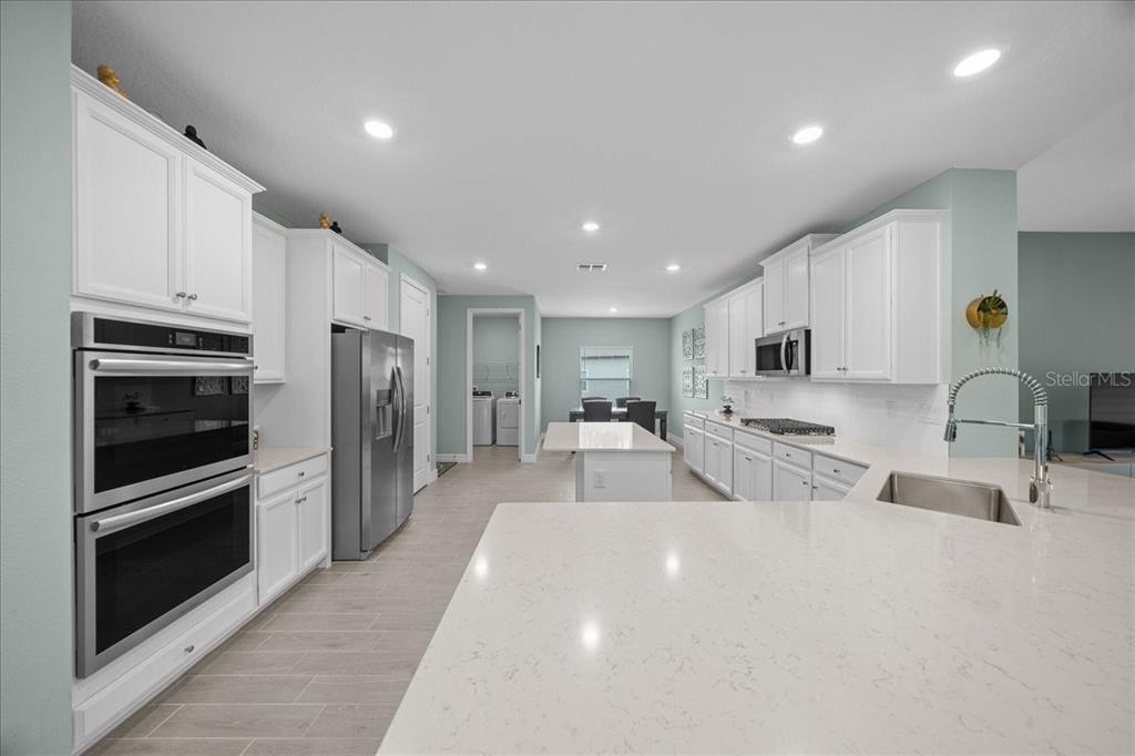 1130 Southeast 42nd Road Ocala, FL 34480 - Photo 59 of 83 a large white kitchen with stainless steel appliances