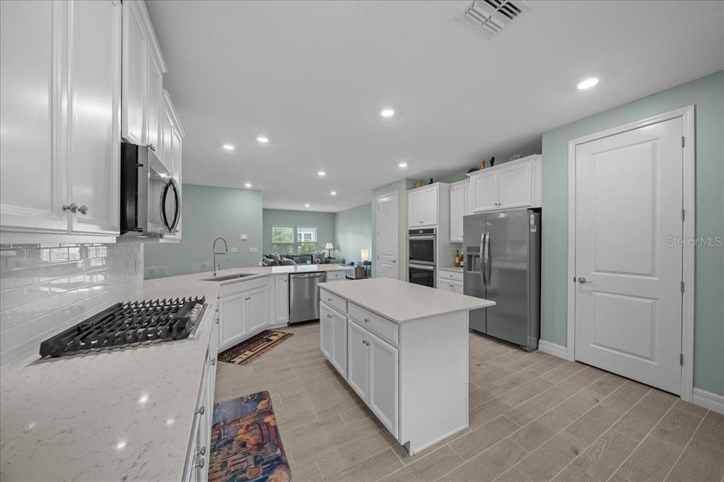 1130 Southeast 42nd Road Ocala, FL 34480 - Photo 65 of 83 a kitchen with white cabinets and stainless steel appliances