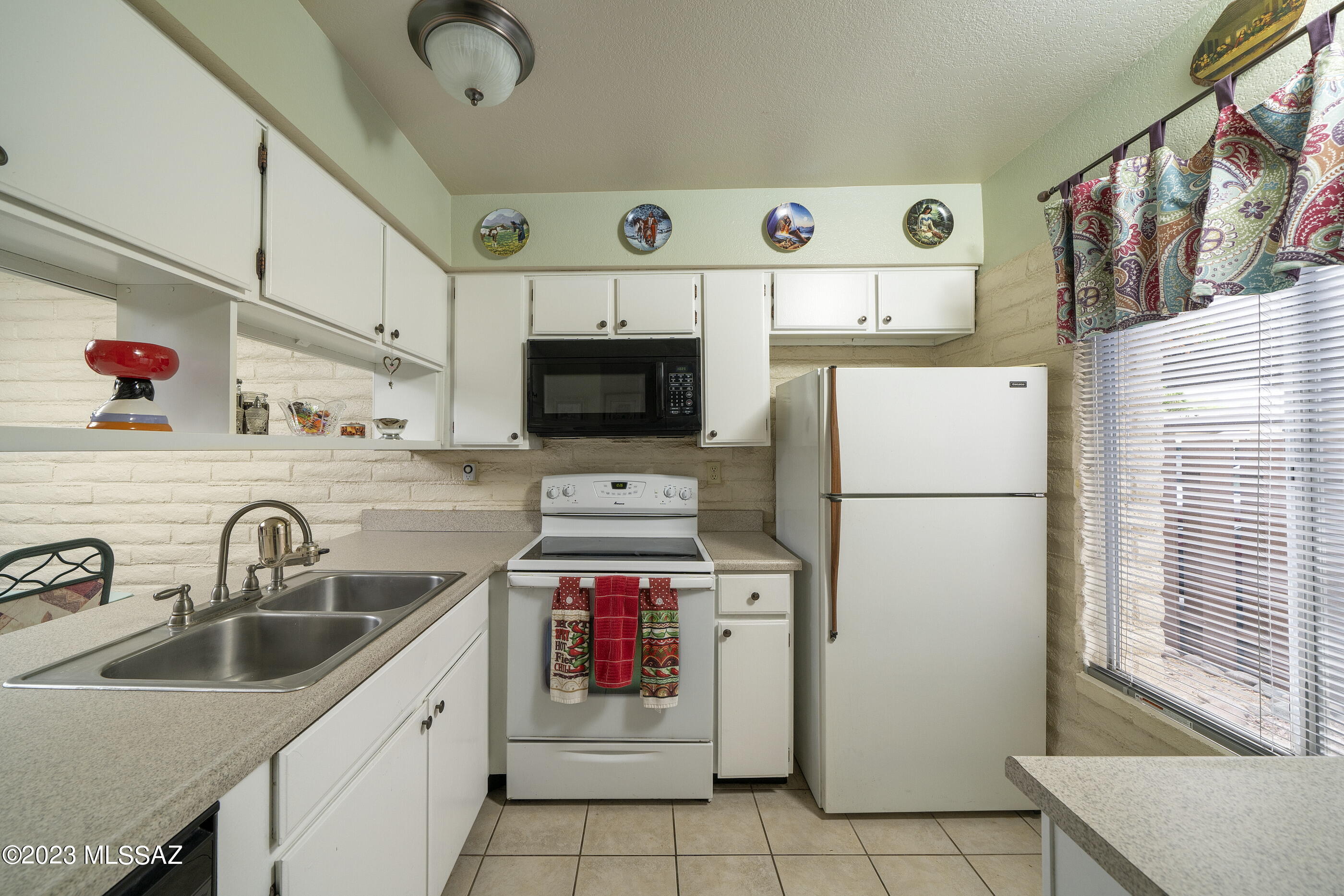 670 South Pantano Road, Unit E Tucson, AZ 85710 - Photo 5 of 17 a kitchen with a sink a stove and refrigerator