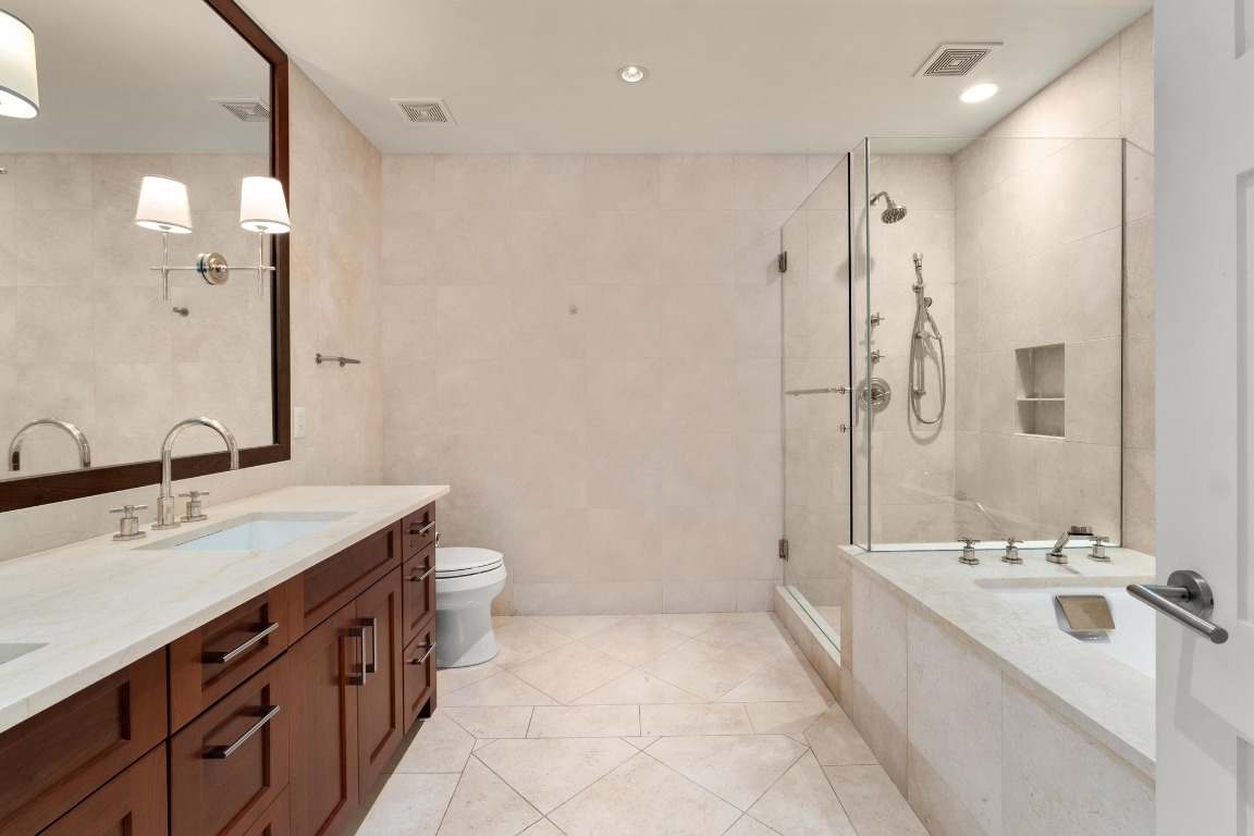 98 San Jacinto Boulevard, Unit 904 Austin, TX 78701 - Photo 13 of 30 a spacious bathroom with a double vanity sink mirror double and shower