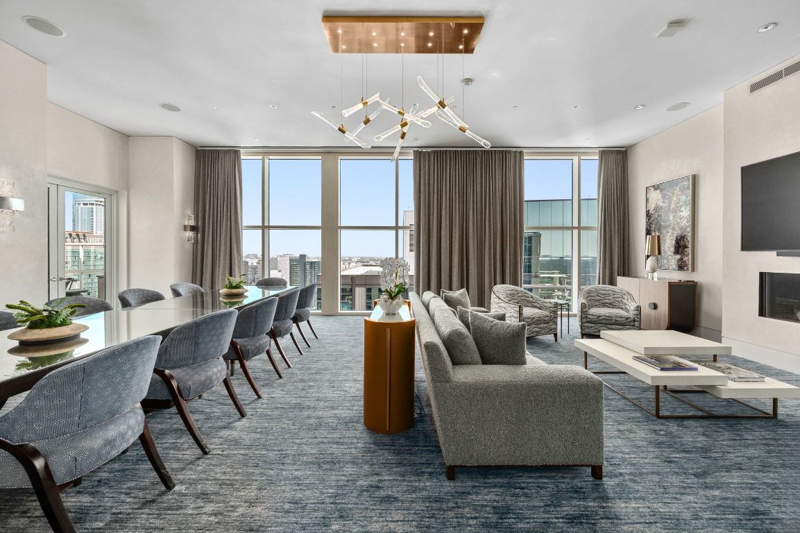 98 San Jacinto Boulevard, Unit 904 Austin, TX 78701 - Photo 25 of 30 a living room with furniture wooden floor and a chandelier