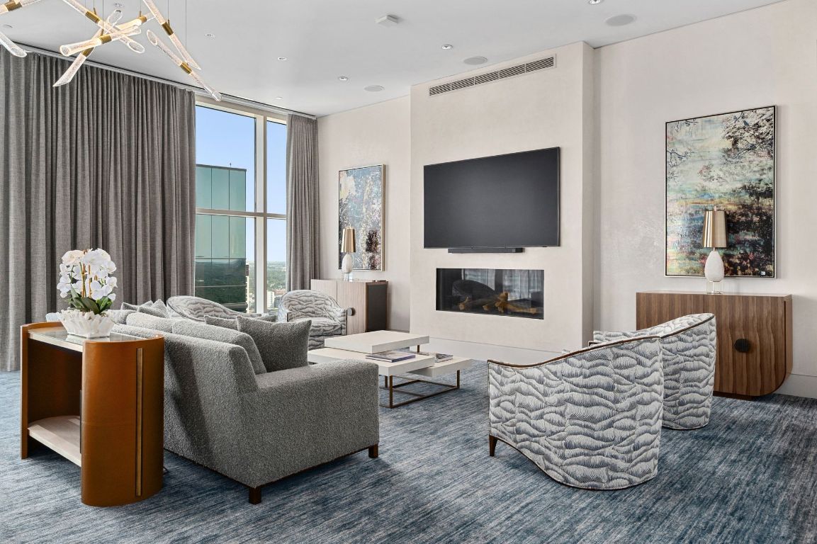 98 San Jacinto Boulevard, Unit 904 Austin, TX 78701 - Photo 26 of 30 a living room with furniture fireplace and a flat screen tv