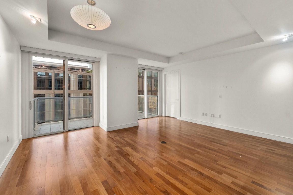 98 San Jacinto Boulevard, Unit 904 Austin, TX 78701 - Photo 5 of 30 an empty room with wooden floor and windows