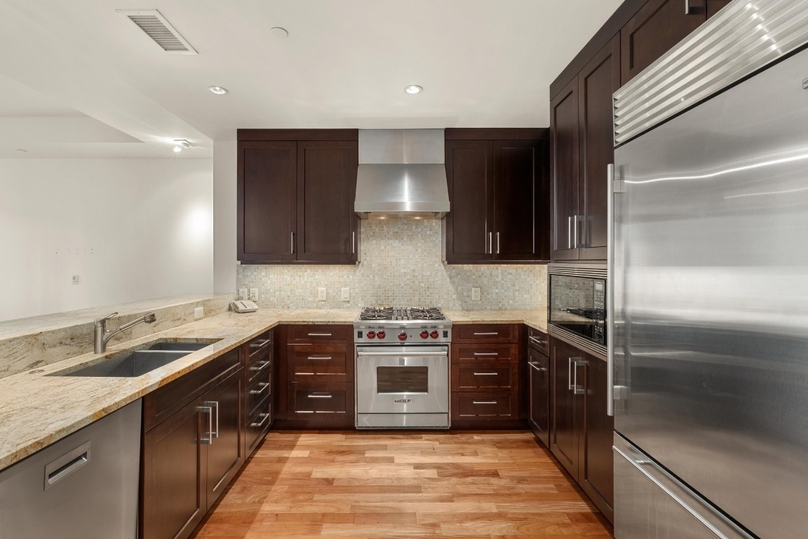 98 San Jacinto Boulevard, Unit 904 Austin, TX 78701 - Photo 7 of 30 a kitchen with stainless steel appliances granite countertop a stove a sink and a refrigerator