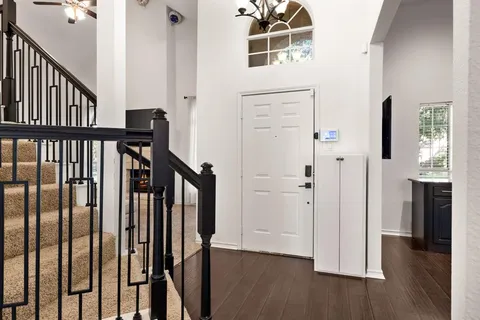 a view of a hallway with wooden floor and stairs