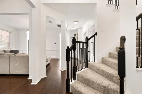 a view of a living room with hardwood floor and a ceiling fan