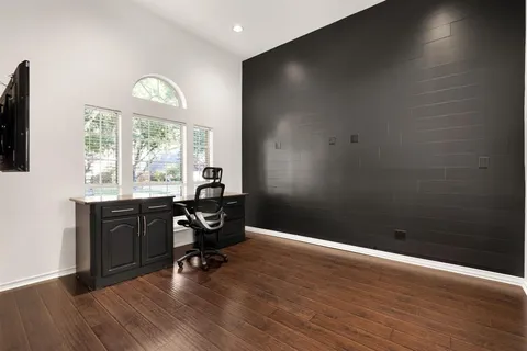 a view of a workspace with furniture and a window