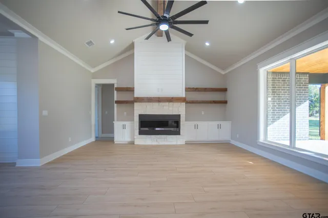 a view of empty room with a fireplace and windows