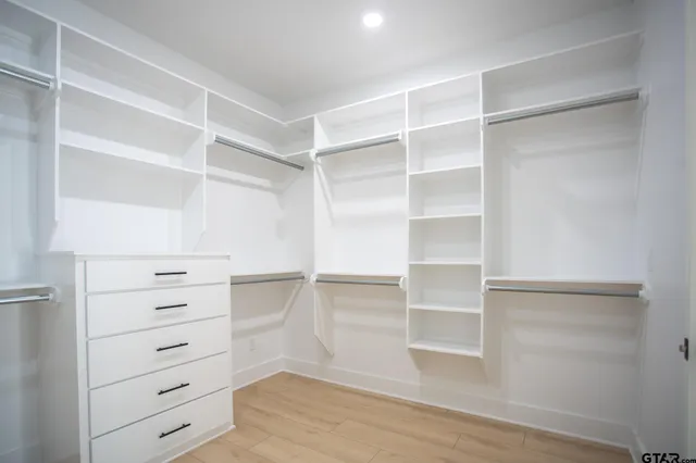 a view of walk in closet with empty racks