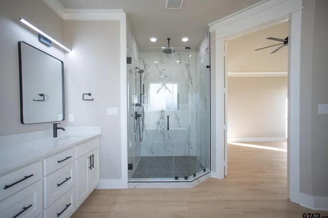 a bathroom with a shower sink and mirror
