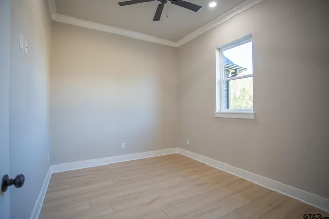 an empty room with a window and a ceiling fan