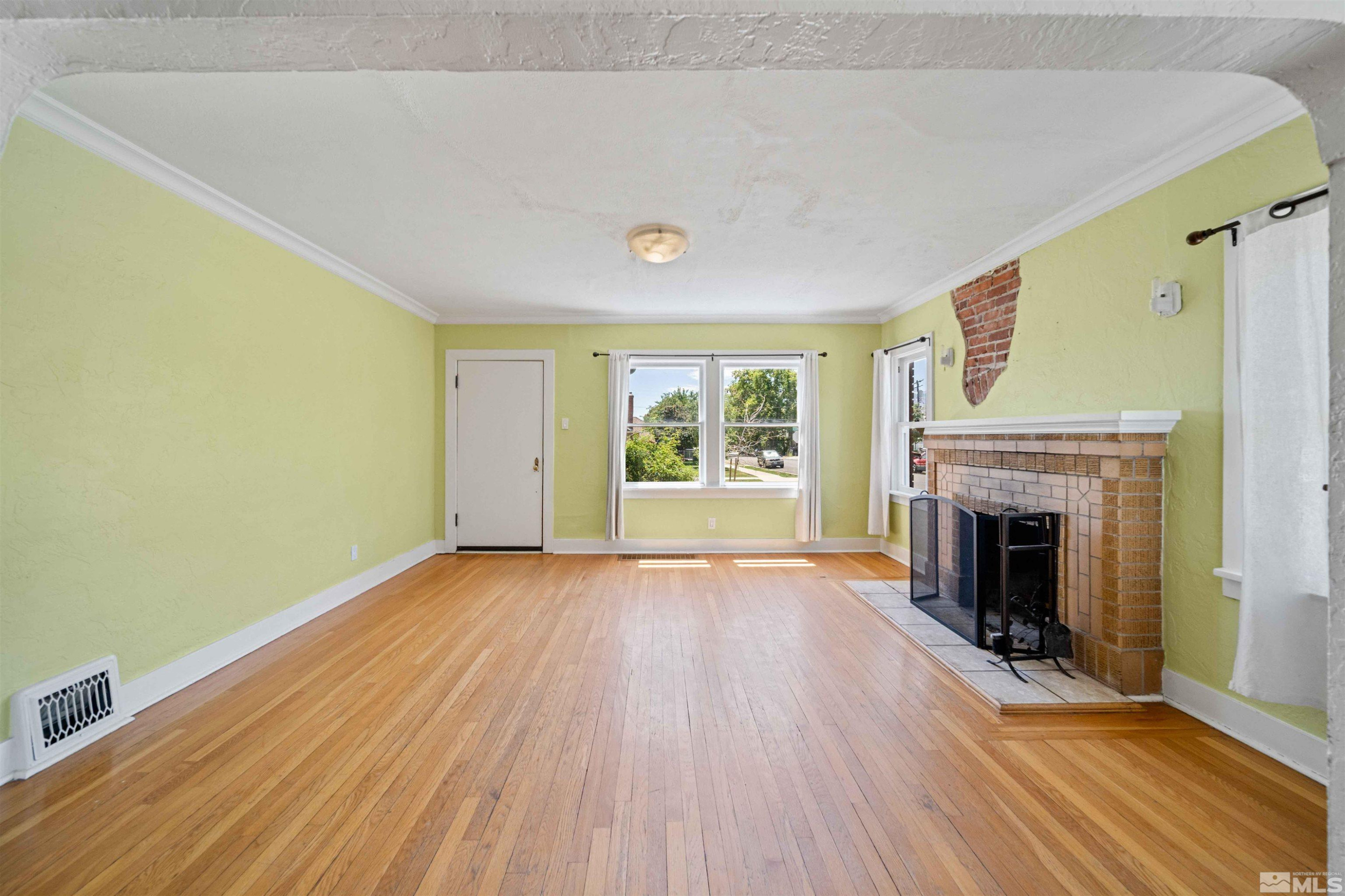 511 Cheney Street Reno, NV 89502 - Photo 6 of 31 a view of an empty room with window wooden floor and fire place