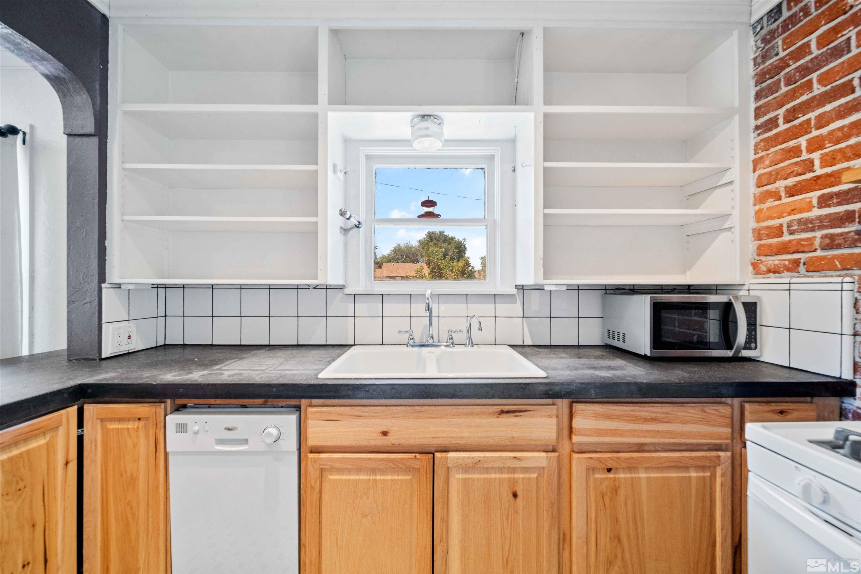 511 Cheney Street Reno, NV 89502 - Photo 9 of 31 a kitchen with granite countertop a sink and a stove next to a window