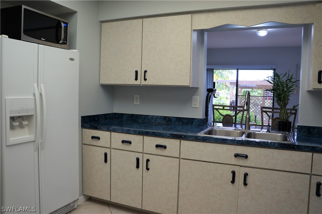 30337 Beech Road Punta Gorda, FL 33982 - Photo 21 of 33 a kitchen with granite countertop a stove a sink and a white cabinets