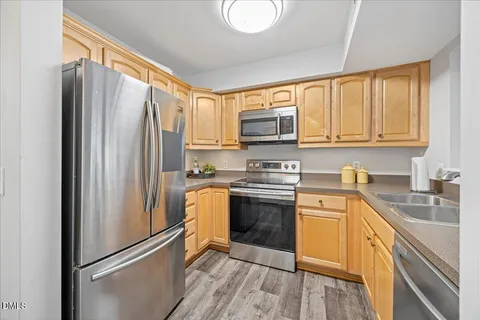 a kitchen with stainless steel appliances granite countertop a refrigerator stove and sink