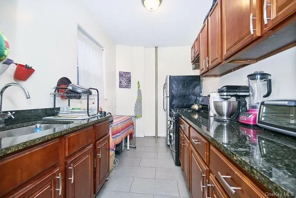 a kitchen with kitchen island granite countertop a sink stove and cabinets