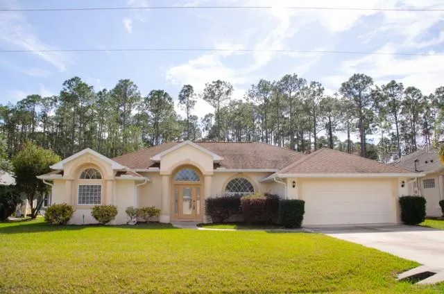 a view of a house with yard and sitting area