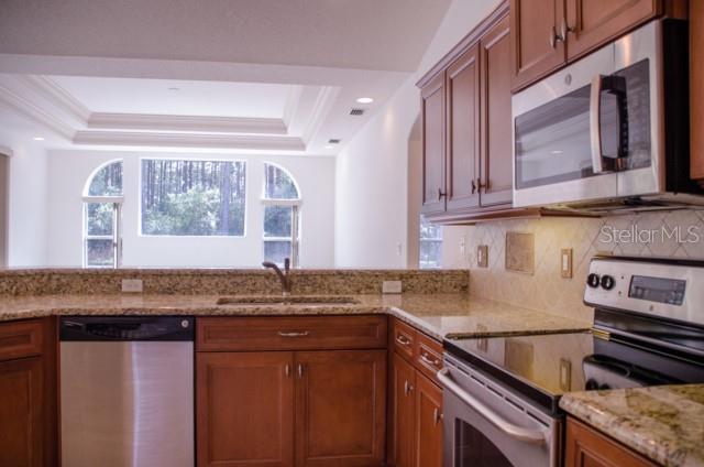 8 Eastland Lane Palm Coast, FL 32164 - Photo 25 of 60 a kitchen with stainless steel appliances granite countertop a sink stove and cabinets
