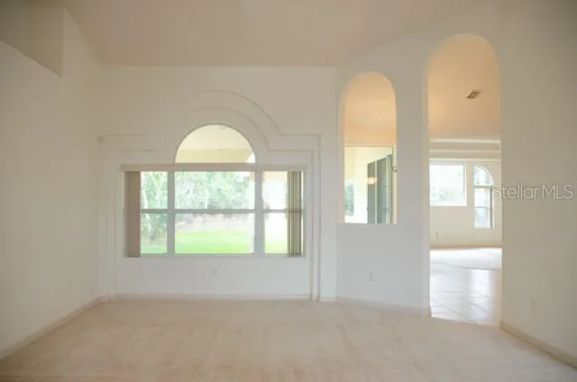 an empty room with a window and a fan