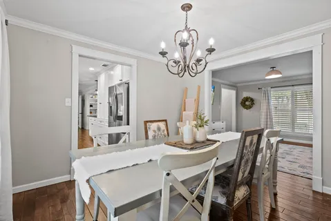 a view of a dining room with furniture wooden floor and chandelier