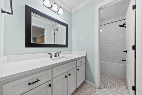a bathroom with a double vanity sink mirror and bathtub