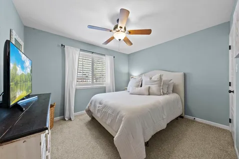 a bedroom with a bed window and flat screen tv