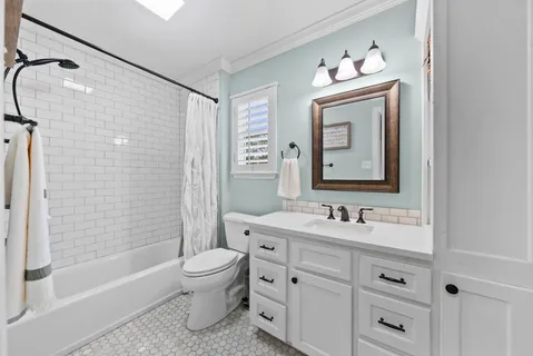 a bathroom with a double vanity sink toilet mirror and shower