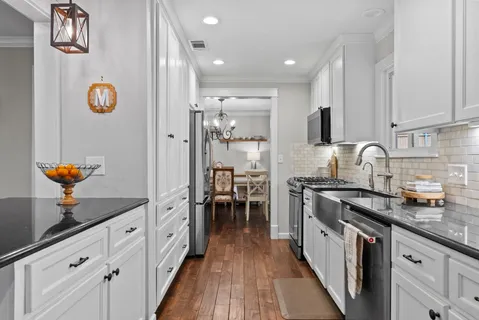 a kitchen with stainless steel appliances granite countertop a sink stove and refrigerator