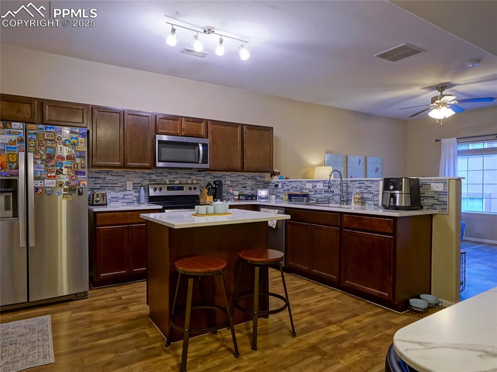 4792 Kerry Lynn View Colorado Springs, CO 80922 - Photo 12 of 34 a kitchen with stainless steel appliances kitchen island granite countertop a refrigerator a stove top oven a sink and dishwasher
