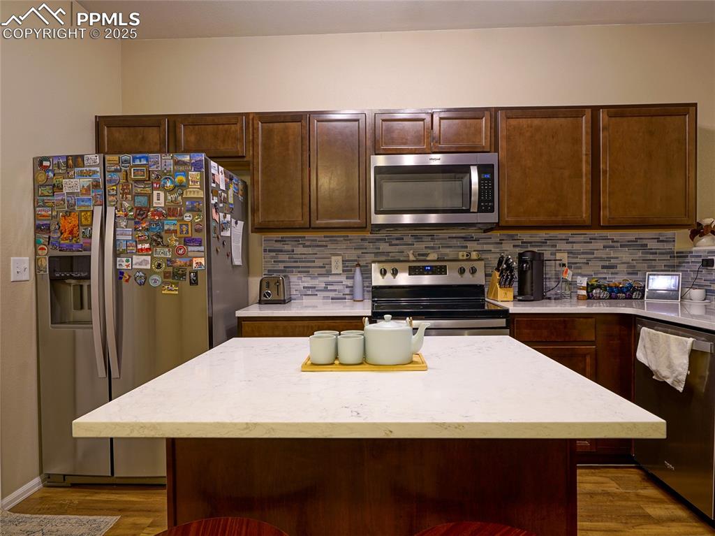 4792 Kerry Lynn View Colorado Springs, CO 80922 - Photo 13 of 34 a kitchen with a wooden floor and refrigerator