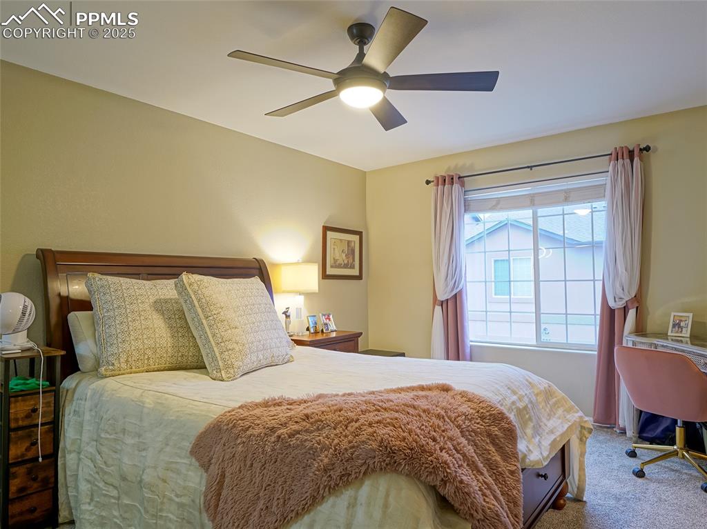 4792 Kerry Lynn View Colorado Springs, CO 80922 - Photo 17 of 34 a bedroom with a large bed and a chandelier fan