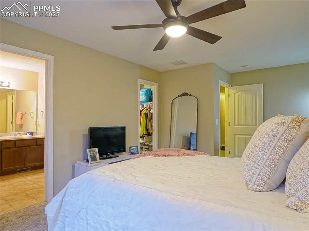 4792 Kerry Lynn View Colorado Springs, CO 80922 - Photo 18 of 31 a bedroom with a large bed and a chandelier