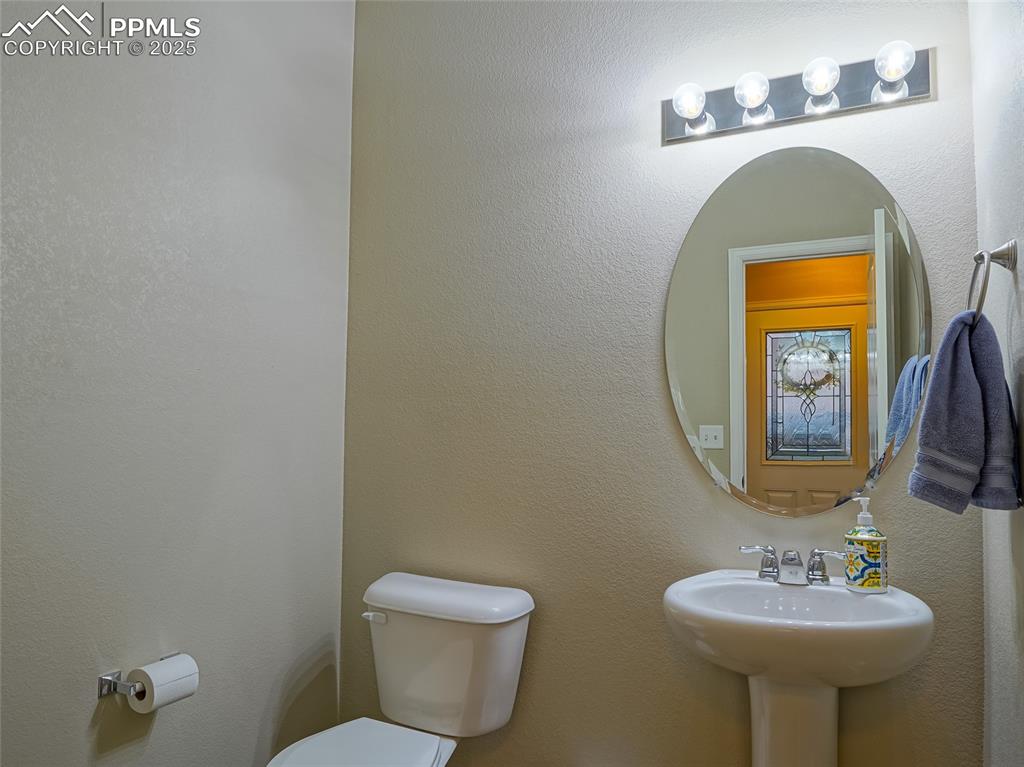 4792 Kerry Lynn View Colorado Springs, CO 80922 - Photo 2 of 31 a bathroom with a toilet sink and mirror