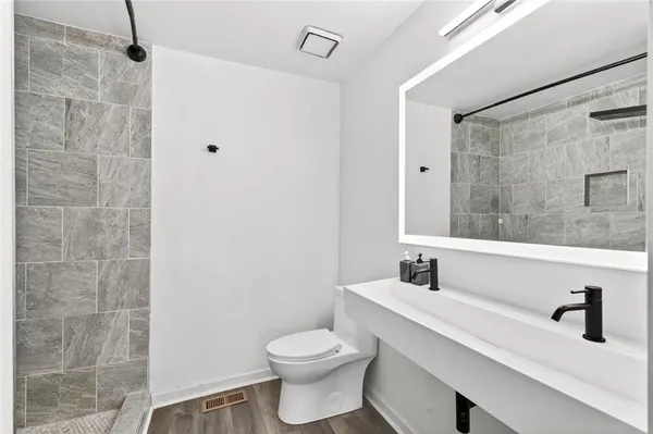 a bathroom with a sink a toilet and shower