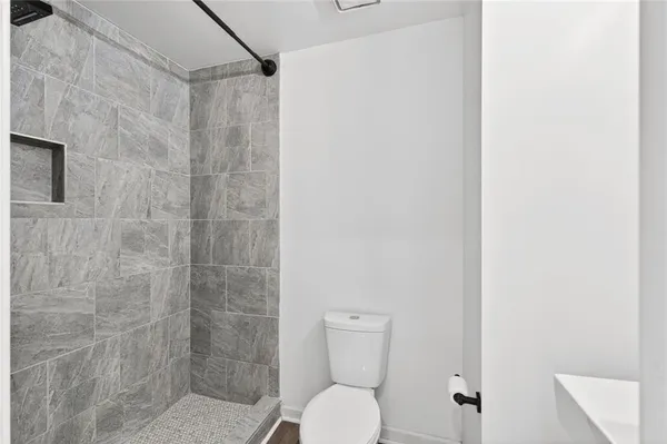 a bathroom with a toilet and a shower